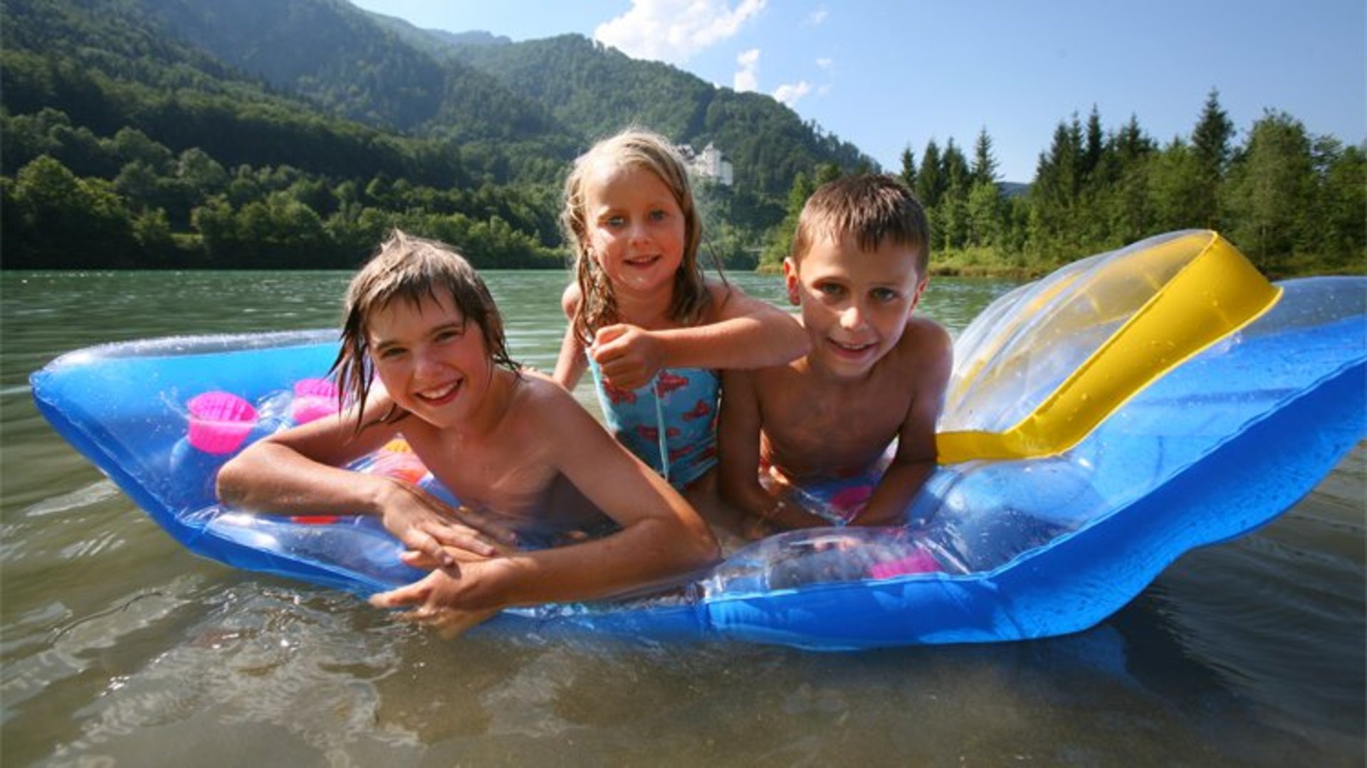 Bathing fun | Photo: Oberösterreich Tourismus GmbH / Röbl Three children on an air mattress enjoying bathing in the Pyhrn-Priel holiday region.