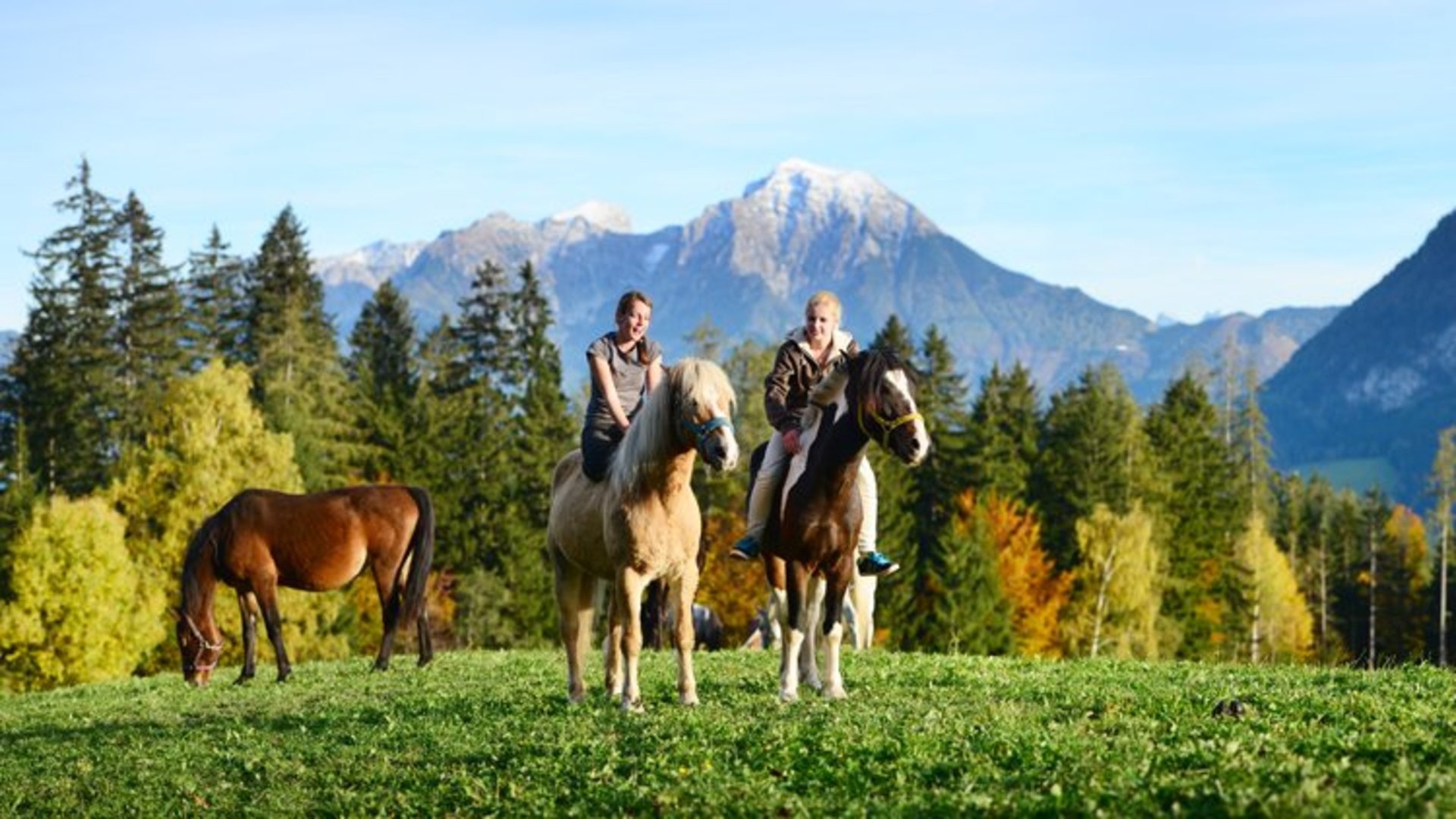 Riding in Pyhrn-Priel | Photo: TVB Pyhrn-Priel / Andreas Röbl Two ladies on a horse and a horse alone with the large and small Pyhrgas in the background.