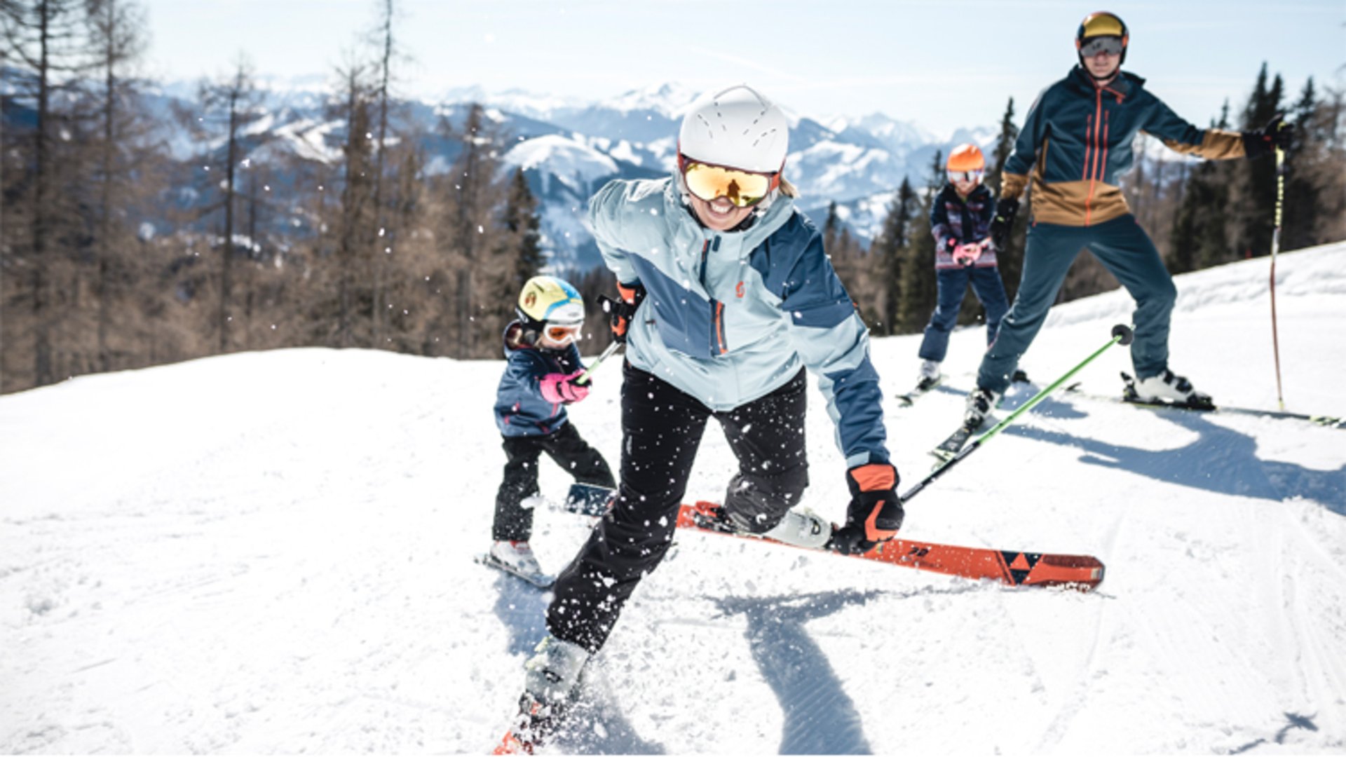 Familien Skiurlaub auf der Wurzeralm | Foto: Oberösterreich Tourismus GmbH/Moritz Ablinger Mutter und Vater ziehen auf der Skipiste ihre Kinder hinterher und dahinter ist ein wunderpares Panorama zu sehen.