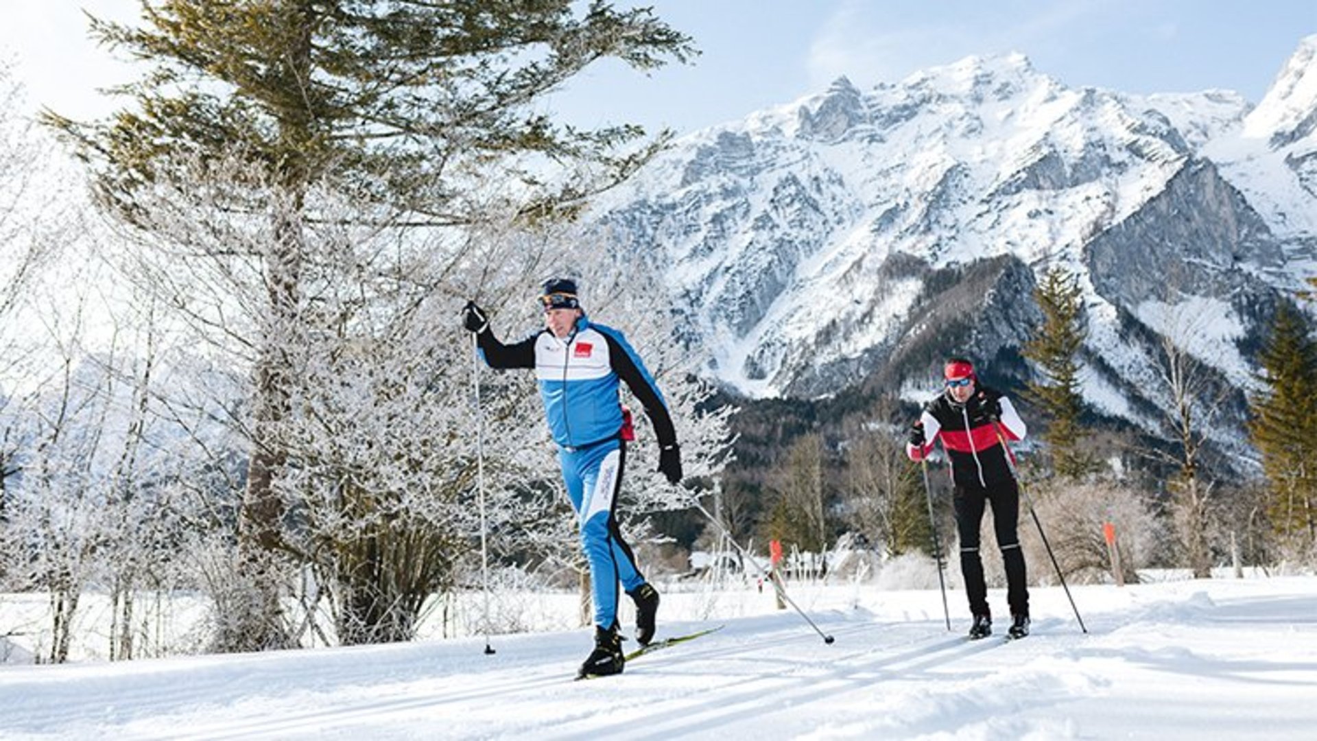 Langlaufen in Pyhrn-Priel | Foto: TVB Pyhrn-Priel/Florian Lierzer Zwei sportliche Langläufer auf der Loipe und Berge im Hintergrund.