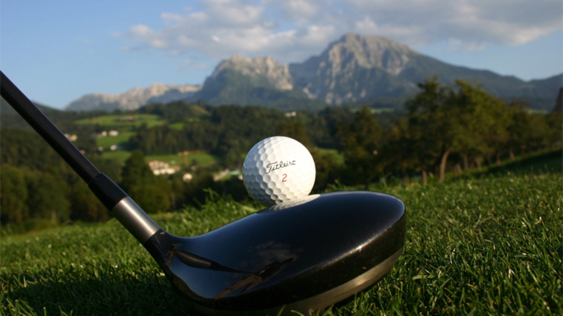 Golf tee in Pyhrn-Priel | Photo: TVB Pyhrn-Priel / Schmid A golf ball and a golf club just before the tee and in the background the big and small Pyhrgas.