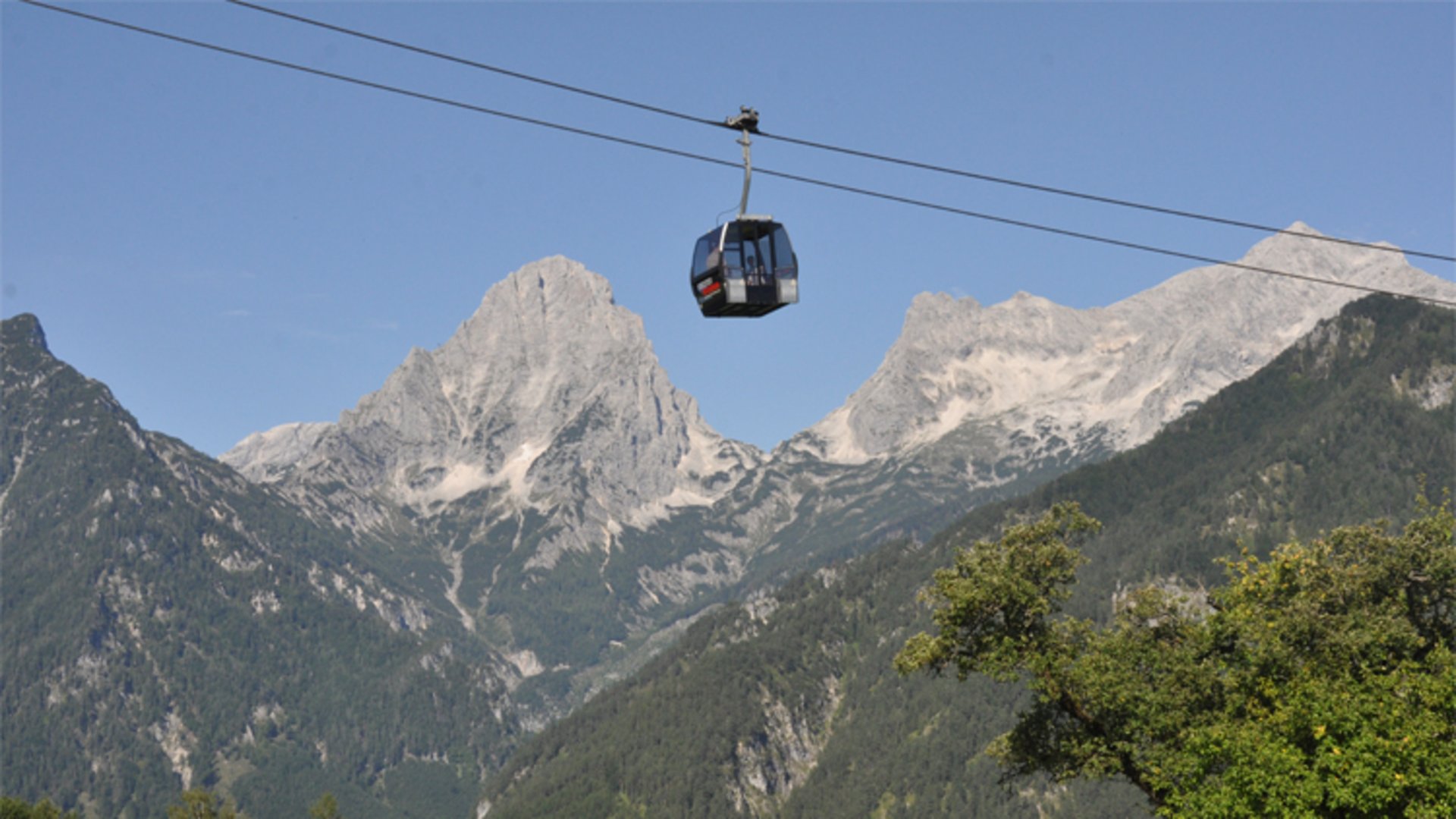 Höss gondola lift | Photo: HIWU / Jack Haijes A gondola of the Höss gondola lift and behind it the Spitzmauer and the large creek.