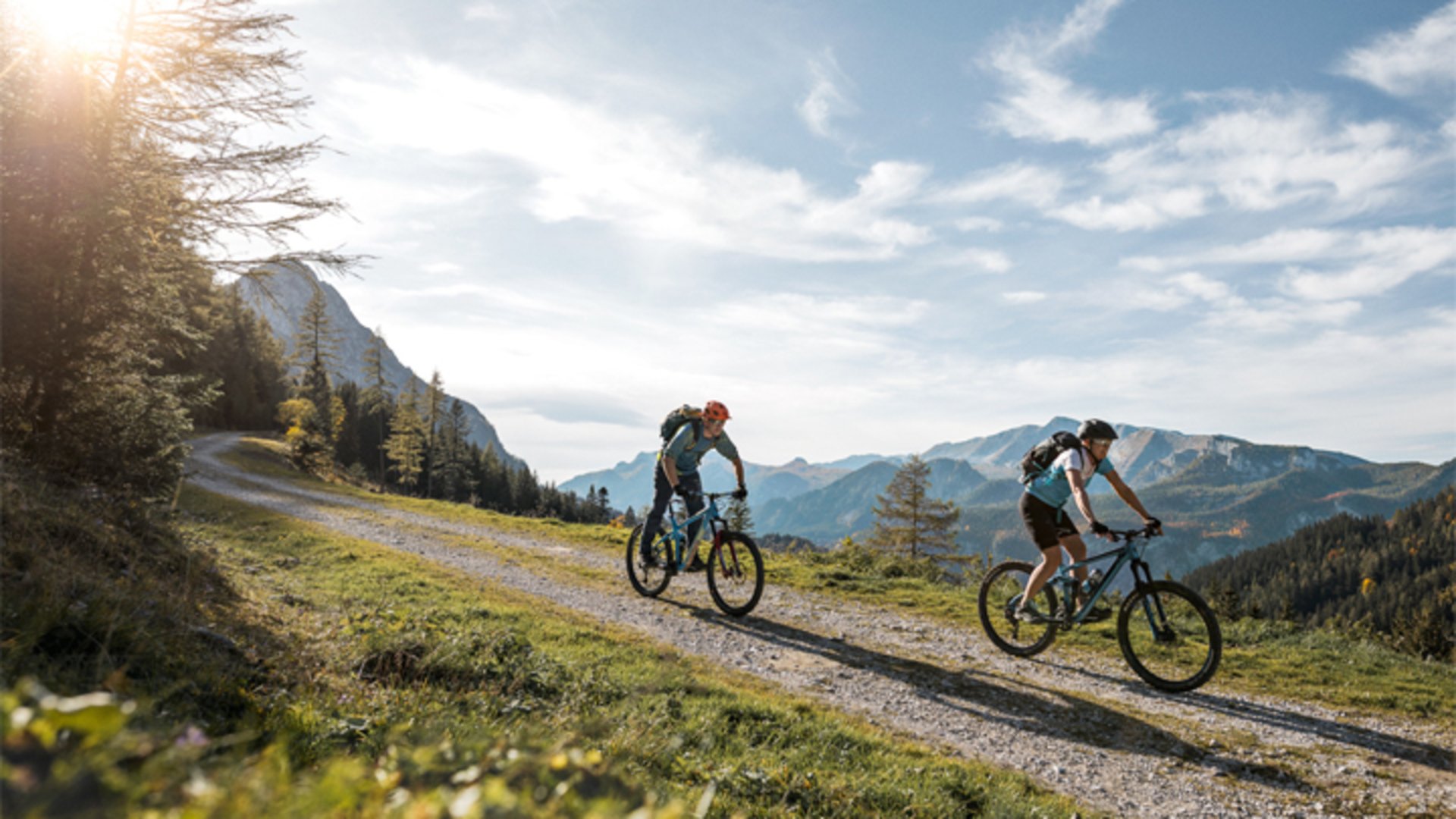 2 mountain bikers mountain panorama | Photo: TVB Pyhrn-Priel / Lierzer Two mountain bikers on a forest road and a mountain panorama in the background.